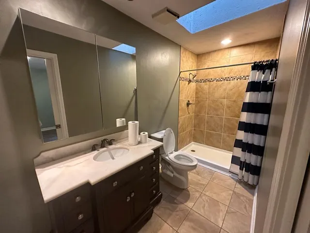 a bathroom with a double vanity sink toilet and shower