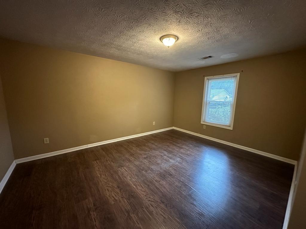 963 Brooklyn Court Norcross, GA 30093 - Photo 9 of 14 an empty room with wooden floor and windows