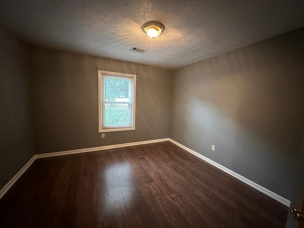 963 Brooklyn Court Norcross, GA 30093 - Photo 10 of 14 an empty room with wooden floor and windows