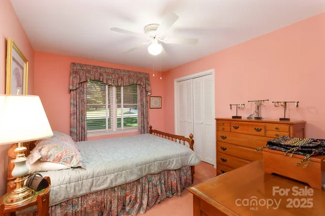 a bedroom with a bed and large windows