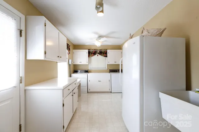 a kitchen with white cabinets and white appliances