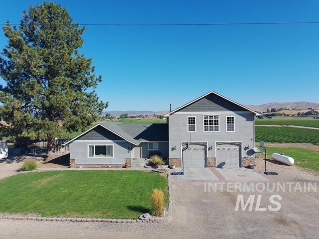 1520 Scheloske Road Weiser, ID 83672 - Photo 35 of 42 Two-story residence with a dual-bay garage, light gray siding, and stone accents