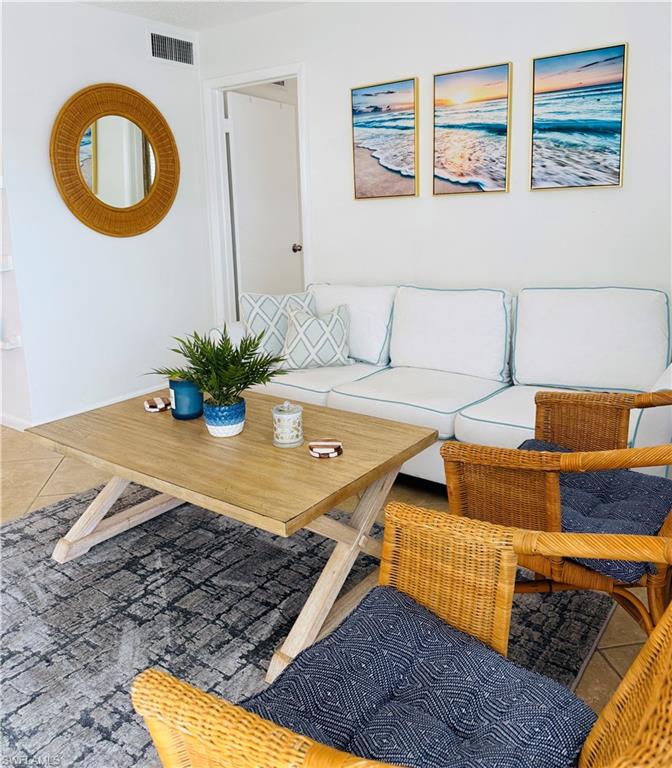 3250 10th Street North, Unit C8 Naples, FL 34103 - Photo 17 of 24 Bright living area featuring tiled flooring, a light wood-finish coffee table, and white walls