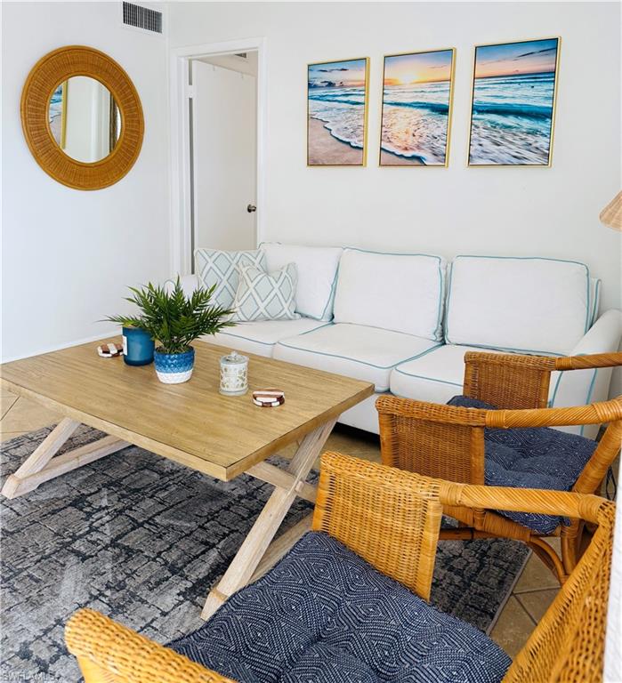 3250 10th Street North, Unit C8 Naples, FL 34103 - Photo 18 of 24 Lounge area featuring a light wood-finish coffee table, white walls, and tiled flooring