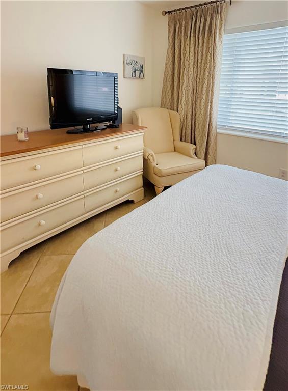 3250 10th Street North, Unit C8 Naples, FL 34103 - Photo 21 of 24 Neutral-toned room featuring light tile flooring and a window with blinds and patterned drapes