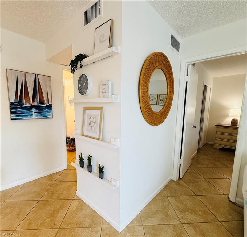 3250 10th Street North, Unit C8 Naples, FL 34103 - Photo 5 of 24 Neutral ceramic tile flooring extends throughout the space