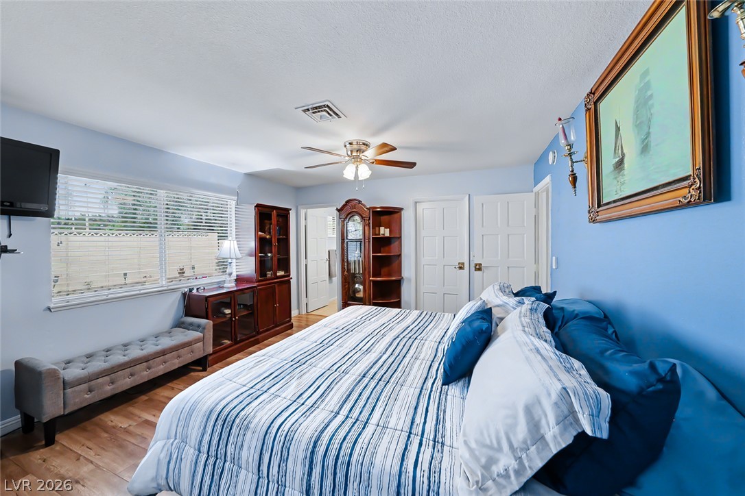 3107 Trueno Road Henderson, NV 89014 - Photo 24 of 37 Hardwood floors and a ceiling fan create a comfortable atmosphere in this well-appointed bedroom.