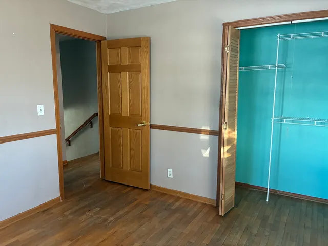 an empty room with wooden floor and a window