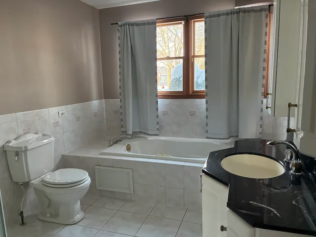 a bathroom with a sink toilet a mirror and bathtub