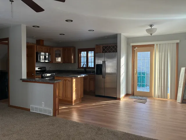 a kitchen with granite countertop a refrigerator and a sink