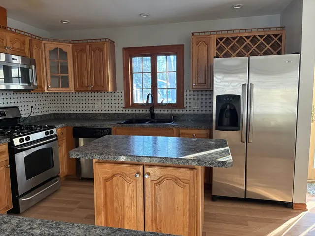 a kitchen with granite countertop a sink stove and refrigerator