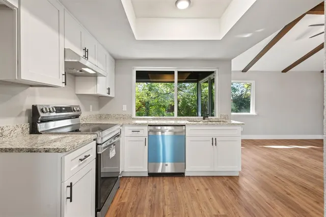 a kitchen with a stove a sink and a microwave