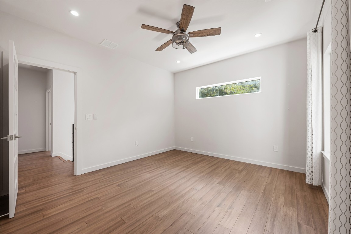3010 Webberville Road, Unit 1 Austin, TX 78702 - Photo 24 of 40 an empty room with wooden floor ceiling fan and windows