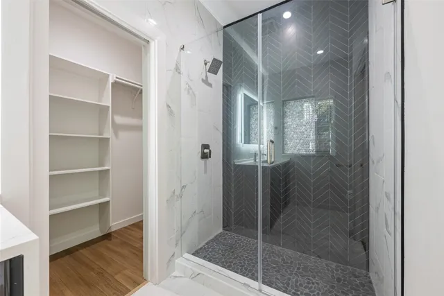 a bathroom with a shower and a glass door