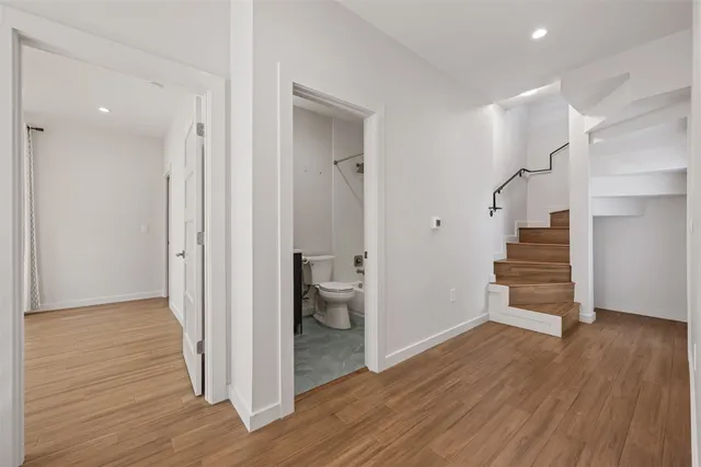 a view of a hallway with wooden floor and entryway