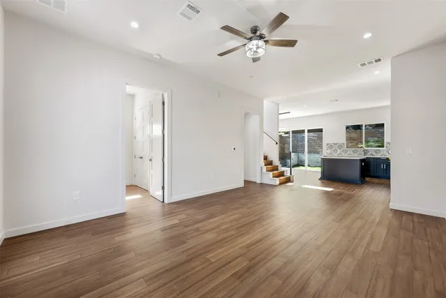 a view of a livingroom with hardwood floor and a ceiling fan