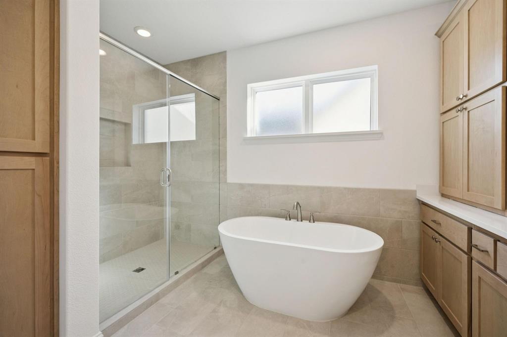 9620 Mav Lane Dallas, TX 75238 - Photo 10 of 11 Full bath featuring a soaking tub, a stall shower, tile walls, a wainscoted wall, and recessed lighting