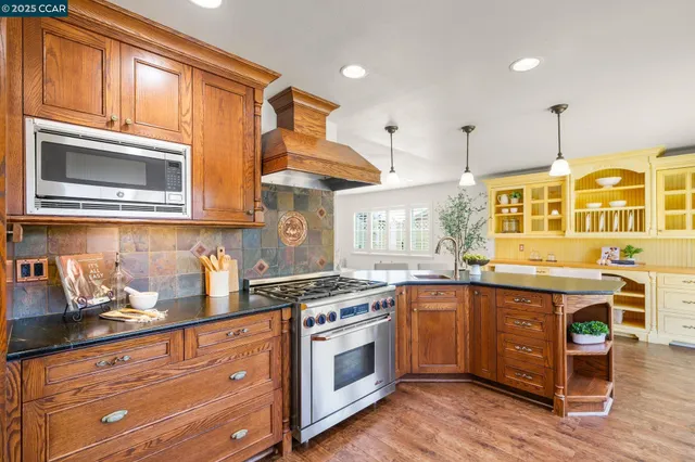 a kitchen with stainless steel appliances granite countertop wooden cabinets and a sink