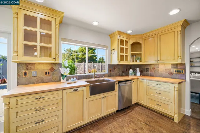 a kitchen with stainless steel appliances granite countertop white cabinets and window