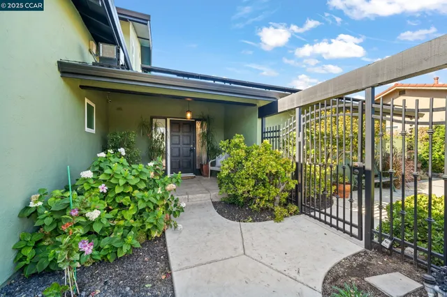 a front view of a house with a lots of flower garden
