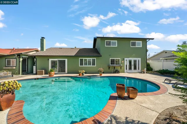 a view of a swimming pool with a patio and plants