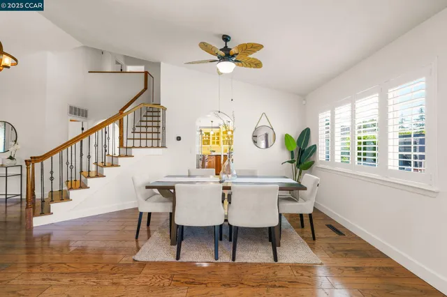 a view of a dining room with furniture a chandelier and wooden floor