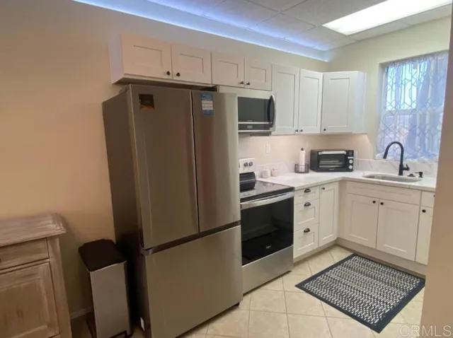 a kitchen with a refrigerator sink stove and cabinets