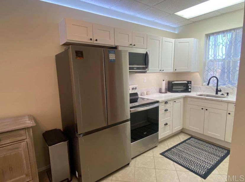 2426 Suncrest Boulevard, Unit B El Cajon, CA 92021 - Photo 3 of 17 a kitchen with a refrigerator sink stove and cabinets