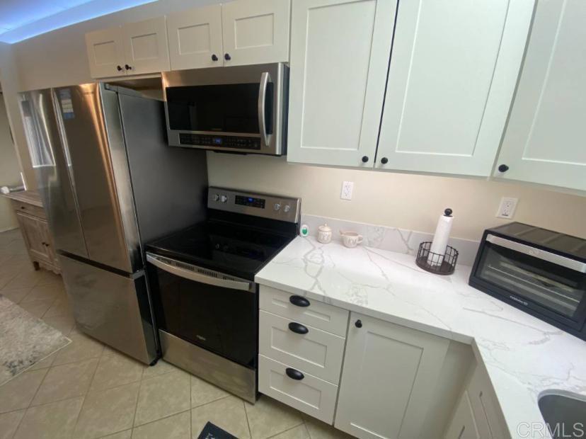2426 Suncrest Boulevard, Unit B El Cajon, CA 92021 - Photo 5 of 17 a kitchen with stainless steel appliances white cabinets and a stove top oven