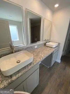 a bathroom with a granite countertop sink and a mirror