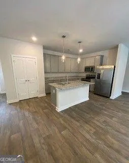 a kitchen with stainless steel appliances granite countertop a stove a refrigerator and a microwave