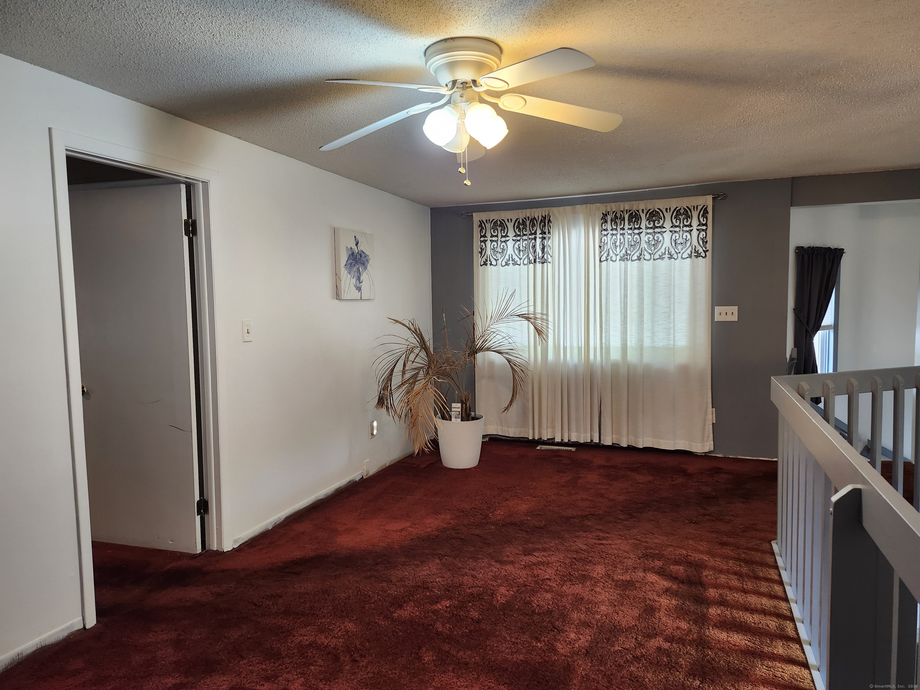 39 Loren Circle Windsor, CT 06095 - Photo 12 of 16 a view of an empty room with window a ceiling fan and front door
