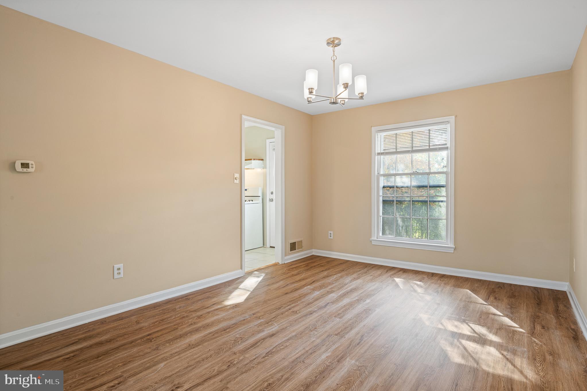 9713 Byeforde Road Kensington, MD 20895 - Photo 18 of 56 a view of an empty room with wooden floor and a window