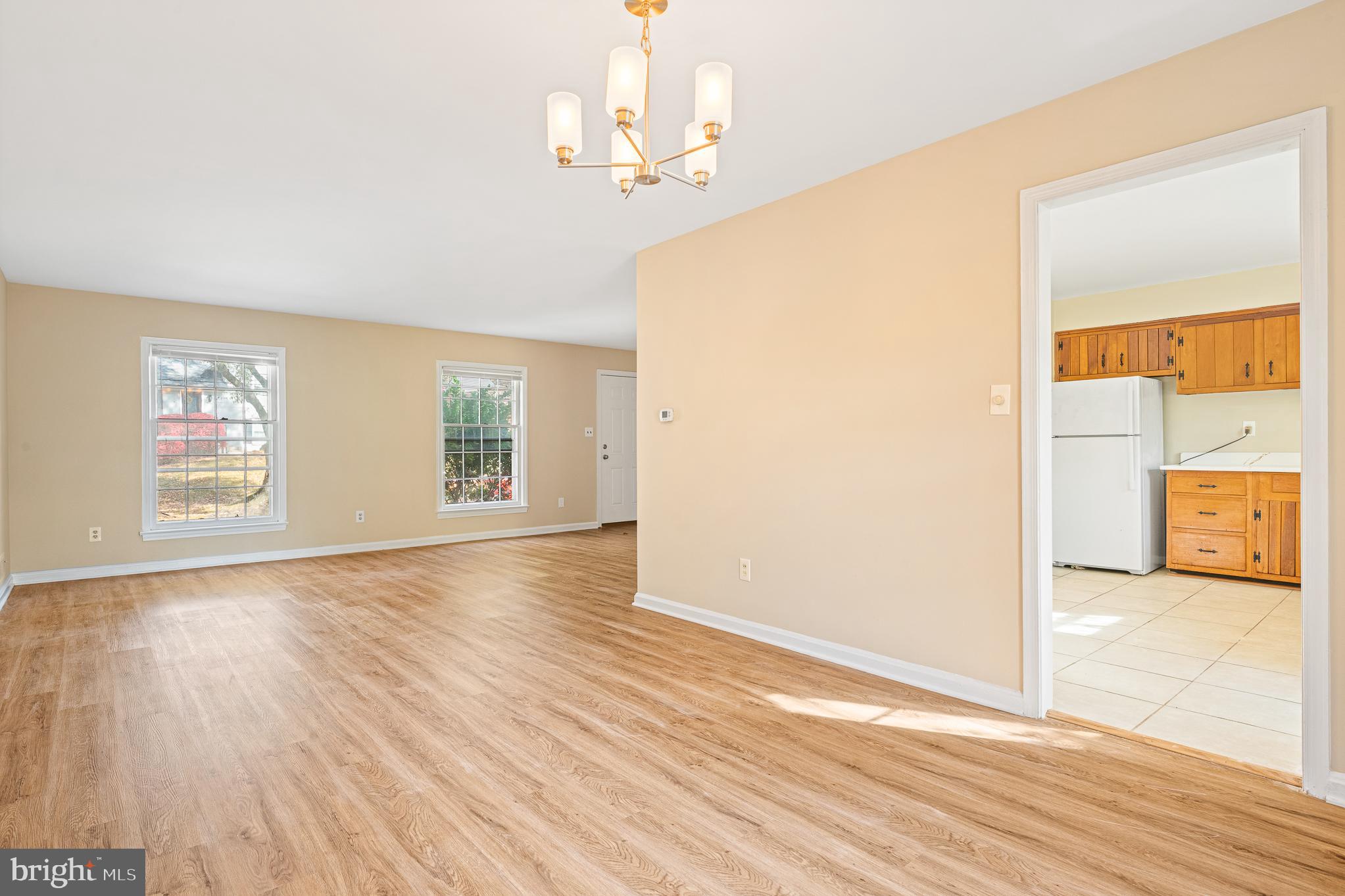 9713 Byeforde Road Kensington, MD 20895 - Photo 19 of 56 an empty room with wooden floor and windows