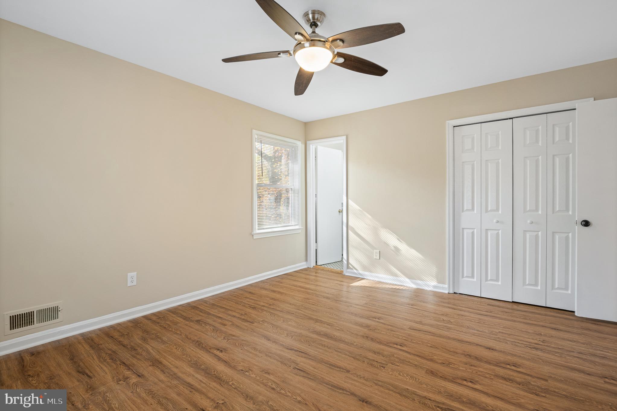 9713 Byeforde Road Kensington, MD 20895 - Photo 31 of 56 an empty room with wooden floor chandelier fan and windows