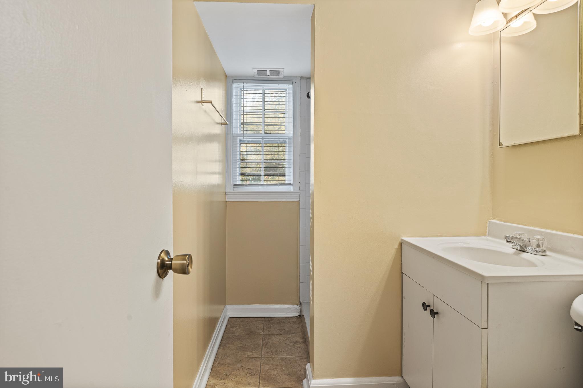 9713 Byeforde Road Kensington, MD 20895 - Photo 37 of 56 a bathroom with a sink a mirror and shower