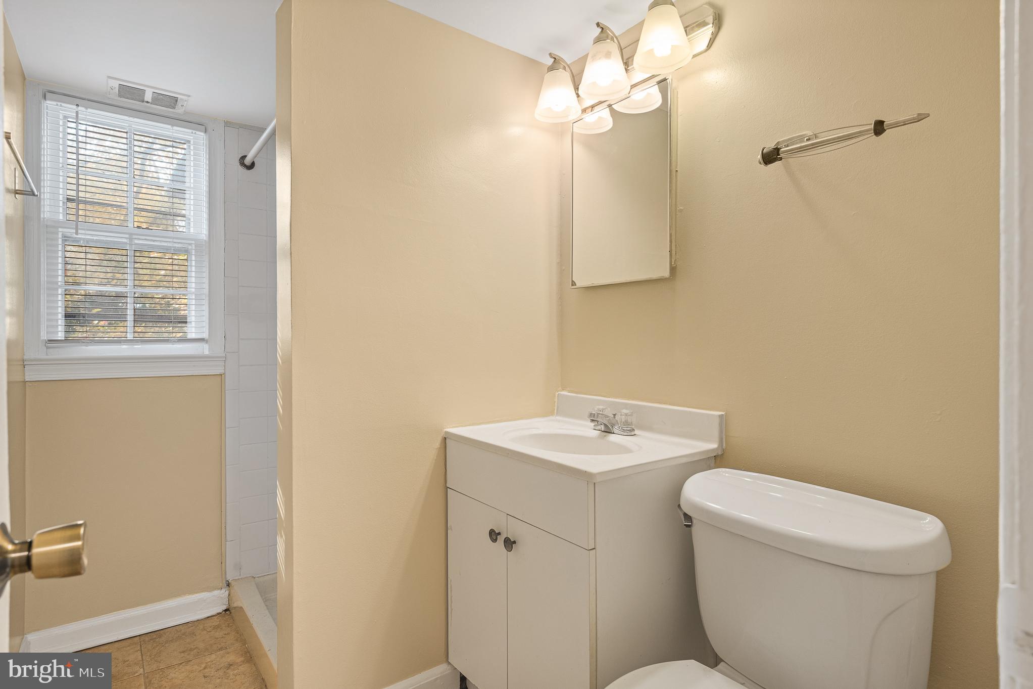 9713 Byeforde Road Kensington, MD 20895 - Photo 38 of 56 a bathroom with a toilet a sink and mirror
