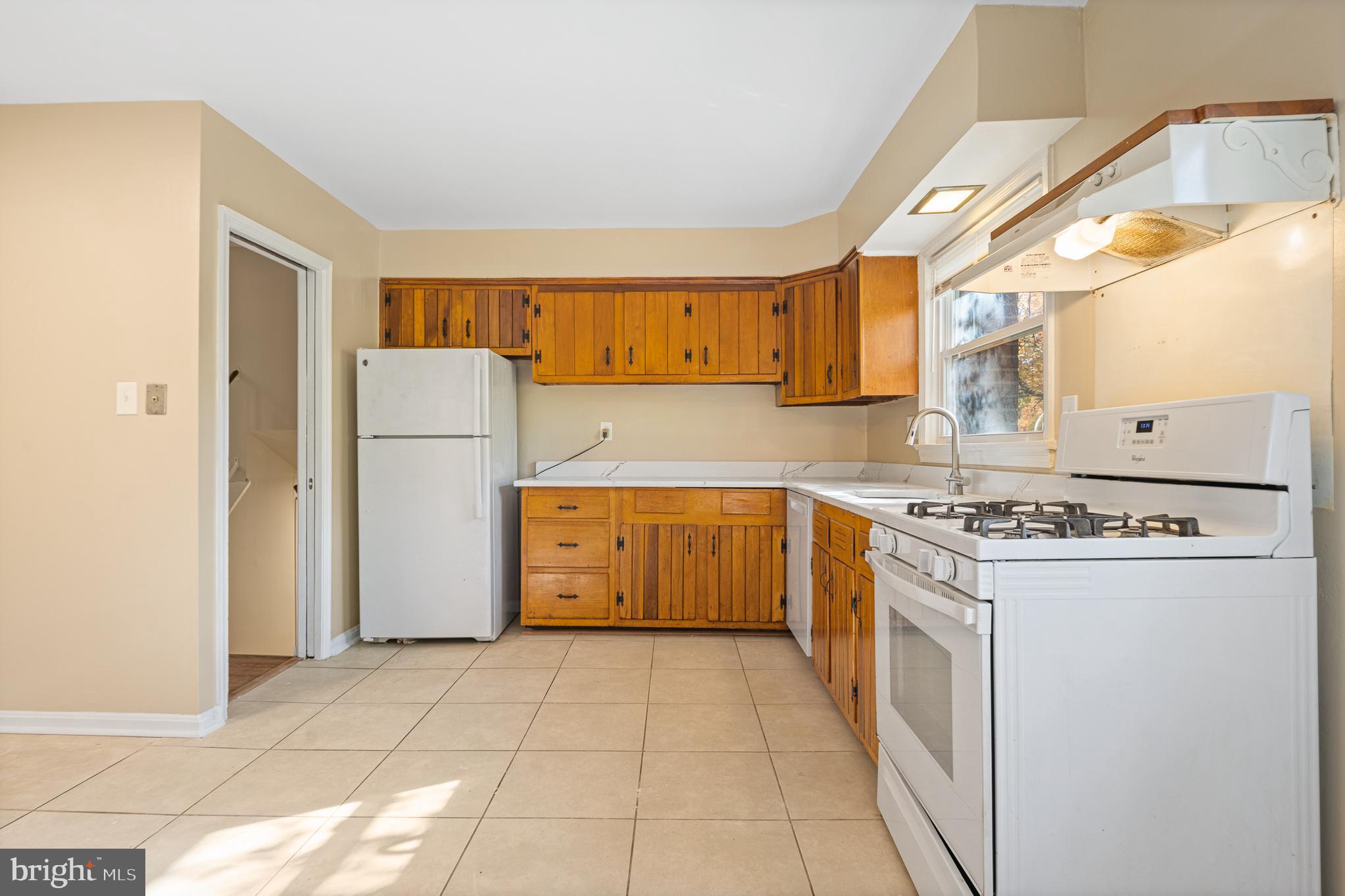 9713 Byeforde Road Kensington, MD 20895 - Photo 5 of 56 a kitchen with a stove a refrigerator and a sink
