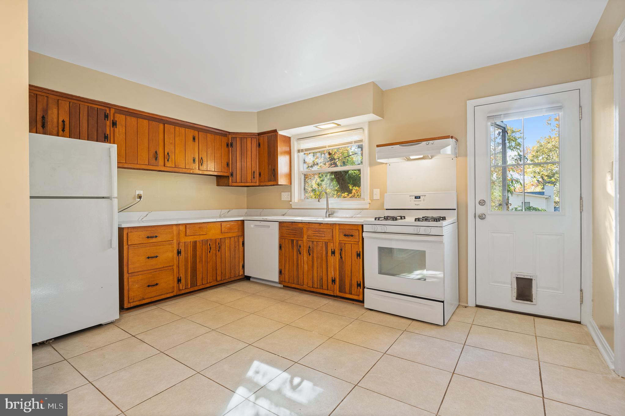 9713 Byeforde Road Kensington, MD 20895 - Photo 6 of 56 a kitchen with a stove sink and a refrigerator