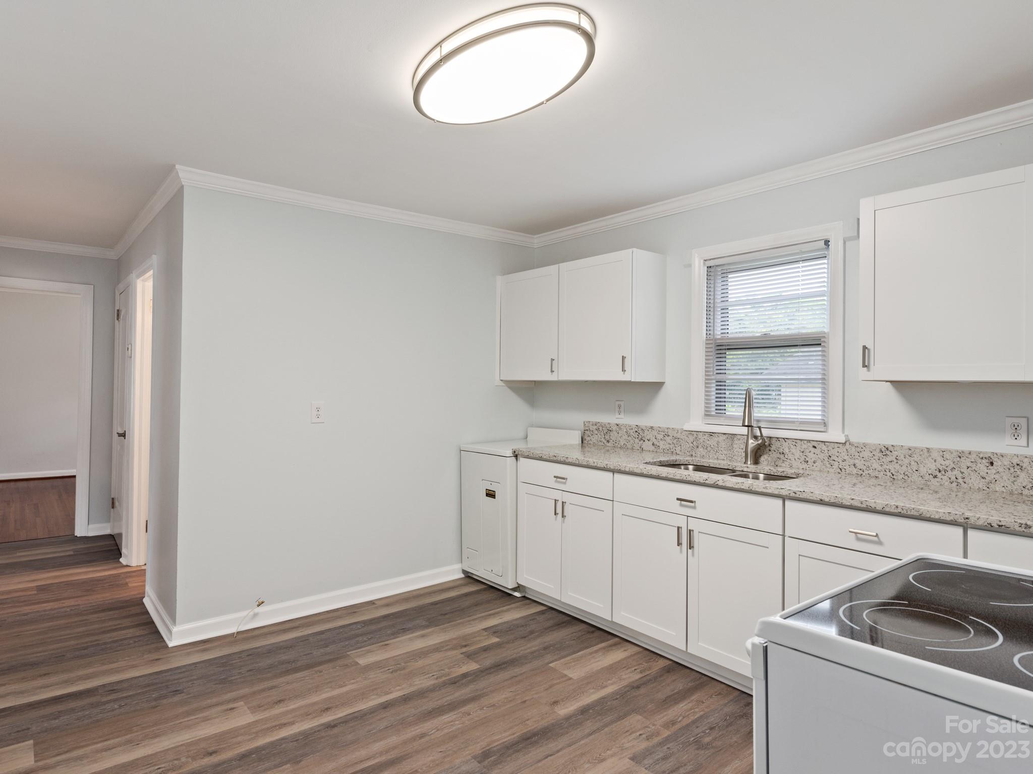 342 Union Cemetery Road Southwest Concord, NC 28027 - Photo 6 of 30 a kitchen with granite countertop a sink cabinets and wooden floor