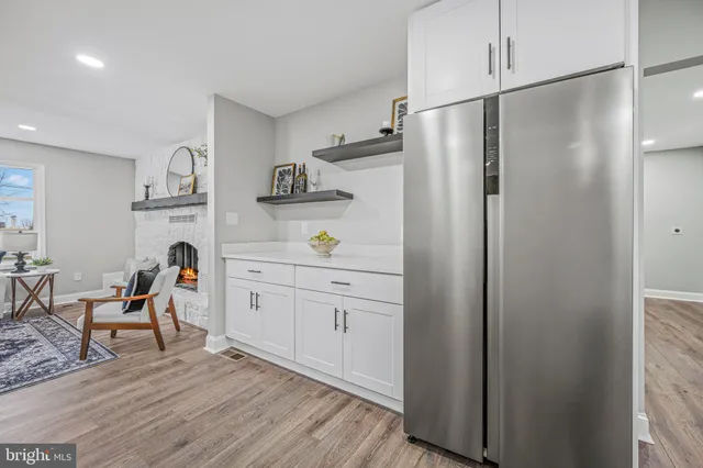 a kitchen with stainless steel appliances granite countertop a stove top oven a sink and white cabinets