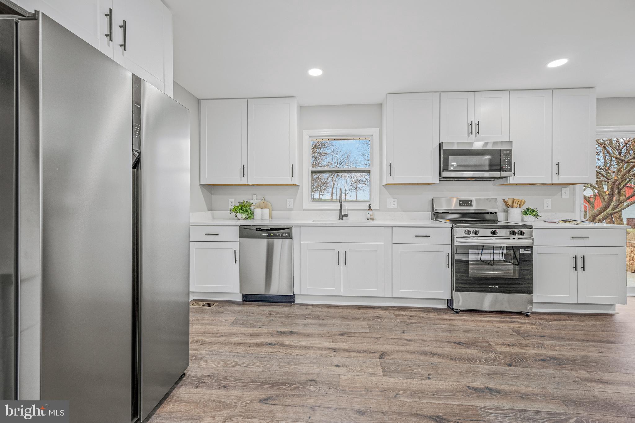 17731 Mason Dixon Road Hagerstown, MD 21740 - Photo 13 of 51 a kitchen with stainless steel appliances granite countertop a stove top oven a sink and white cabinets