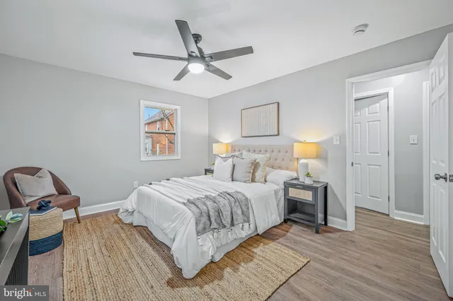 an empty room with wooden floor ceiling fan and windows