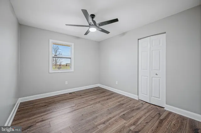 a view of empty room with wooden floor