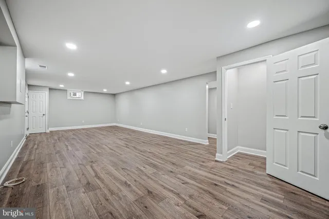 a view of empty room with wooden floor