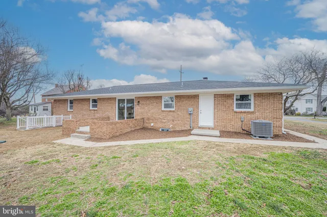 a view of a white house with a yard and sitting area