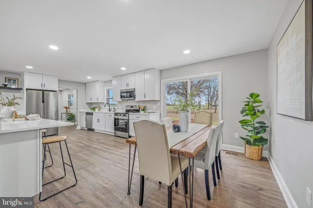 a dining room with furniture and a large window