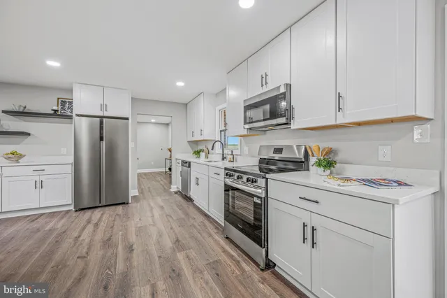 a kitchen with white cabinets and white appliances