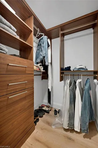 a view of walk in closet with clothes and shoes