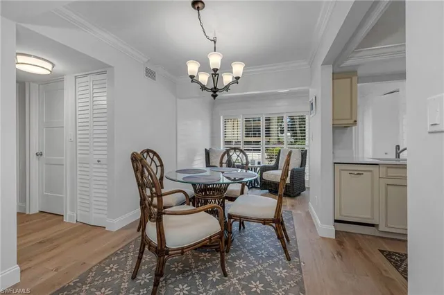 a view of a dining room with furniture a chandelier and wooden floor